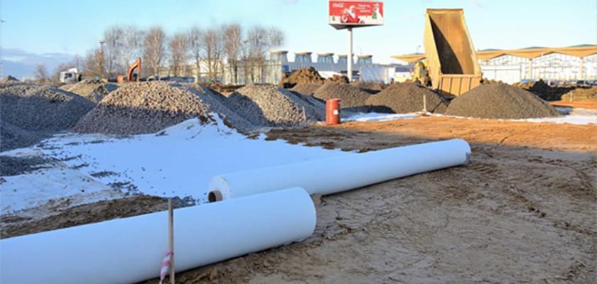 Bạt HDPE màu đen được triển khai trên nền đất yếu, chuẩn bị cho việc xây dựng lớp móng của một con đường cao tốc, đảm bảo chống thấm và ổn định lâu dài