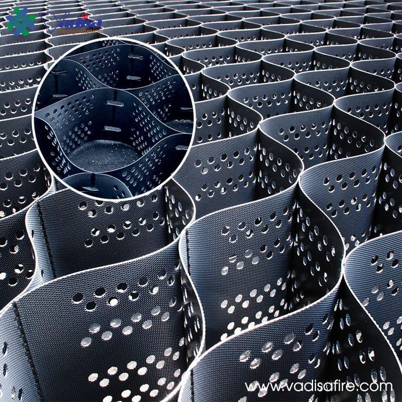 Mô tả chi tiết về ô địa kỹ thuật trồng cỏ với cấu trúc dạng mạng lưới, được thi công trên sườn dốc để chống xói mòn và tạo cảnh quan xanh mát