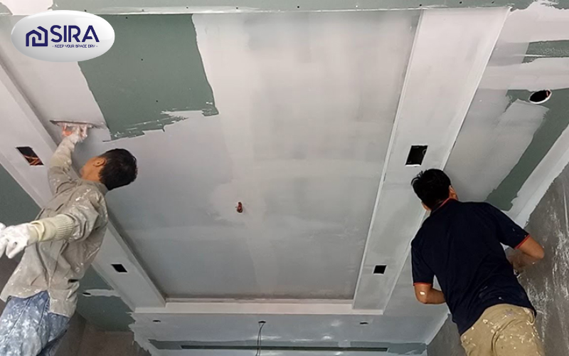 Thợ thi công đang tiến hành trét lớp chống thấm chính lên bề mặt ban công, đảm bảo độ dày và độ phủ đồng đều cho hiệu quả tối ưu.