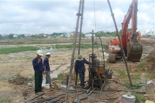 Kỹ sư đang tiến hành khảo sát địa chất công trình bằng máy khoan chuyên dụng để đánh giá nền đất trước khi xây dựng, liên quan đến việc đảm bảo kết cấu vững chắc.