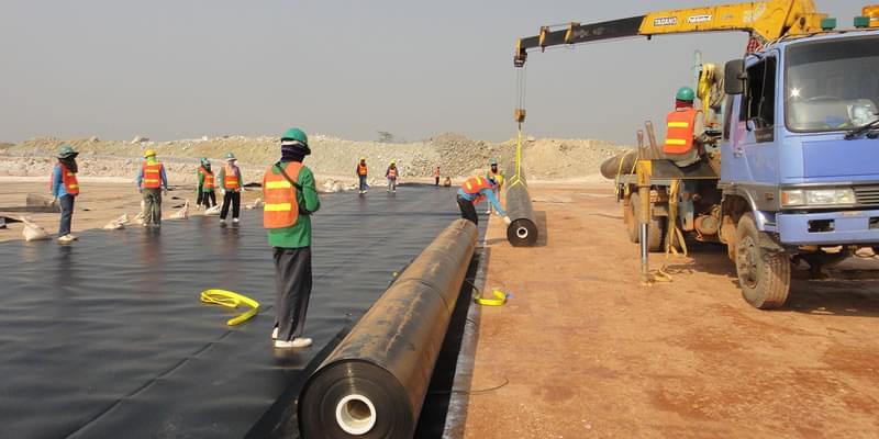 Hình ảnh kỹ sư đang giám sát thi công lớp màng chống thấm HDPE cho bãi chôn lấp chất thải y tế